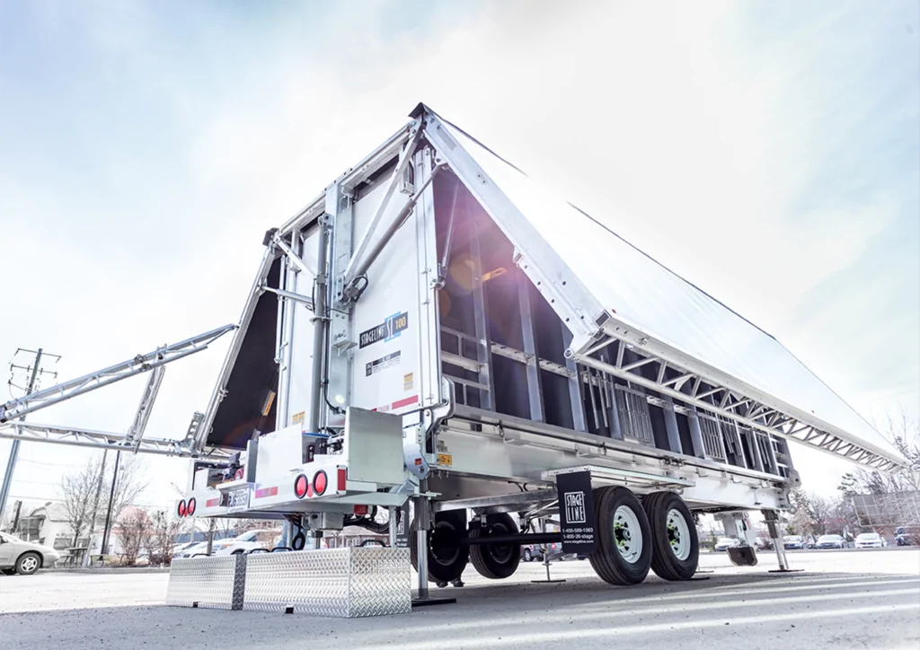 A mobile stage trailer by Neves Media is deployed on a clear day, showcasing a versatile and modern design ideal for outdoor events, with a sturdy structure and ample space for live performances, ensuring a professional setup anywhere.